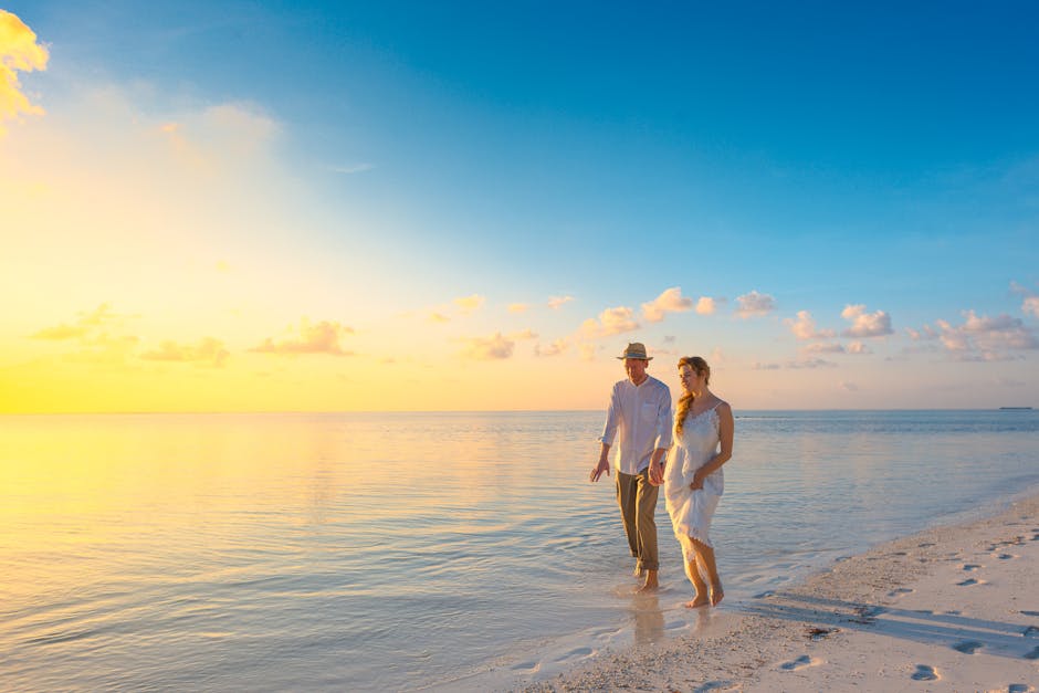 A couple enjoys a romantic walk on a sunny beach in the Maldives at sunrise.